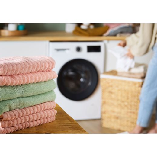 Bosch Series 6 WGG24400GB 9kg Washing Machine with 1400 rpm - White - Folded clothes on table shot